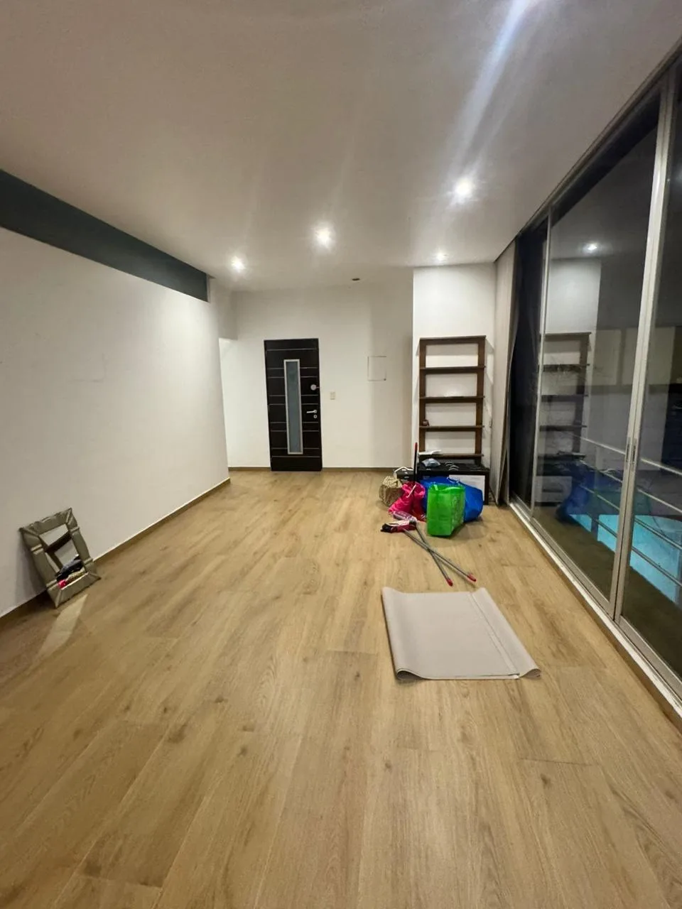 Interior con piso de apariencia madera e iluminación empotrada